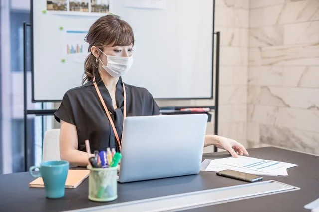 マスクをつけた女性とノートパソコン