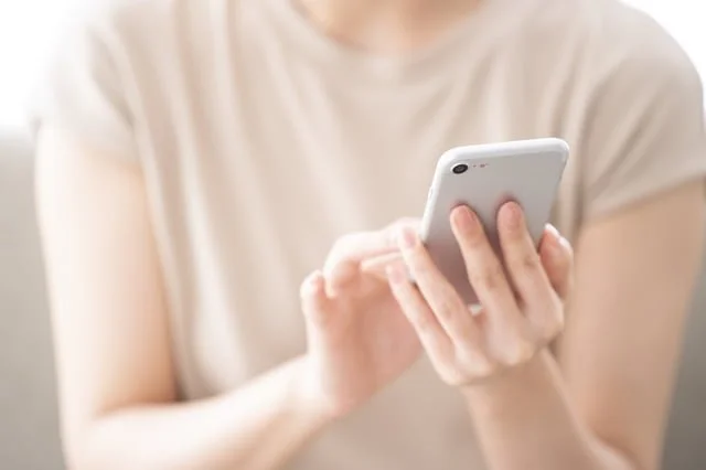 書評-バズる書き方〜書く力が、人もお金も引き寄せる(成毛眞:SB新書) スマホを操作する女性