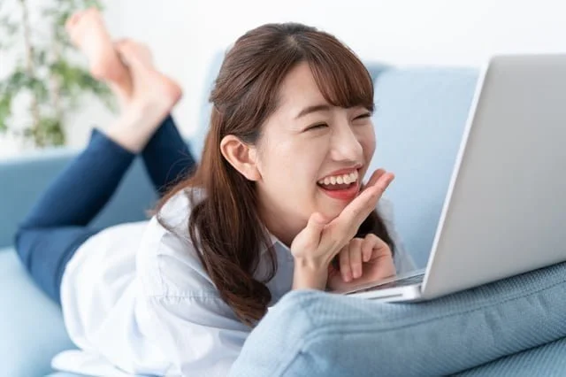 書評-バズる書き方〜書く力が、人もお金も引き寄せる(成毛眞:SB新書) リビングのソファでウェブ会議をする女性