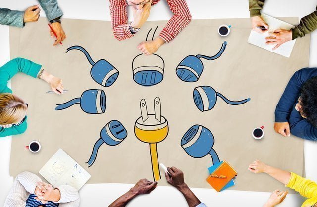 コンセントのイラストを囲む人々